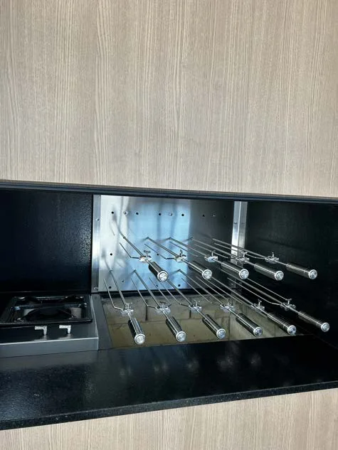 Espetos suspensos com cooktop, em painel de madeira clara